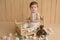 Baby boy sitting on crib. Children Protection Day. Happy childhood. Early child development. Educational wooden toys. Mother`s da