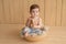 Baby boy sitting on crib. Children Protection Day. Happy childhood. Early child development. Educational wooden toys. Mother`s da