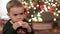 Baby boy sitting near Christmas tree