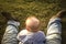 Baby boy sitting over grass between his fathers legs