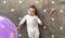 Baby Boy in a white bodysuit lies and plays with a balloon