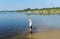 Baby boy in a white undershirt and shorts stand in river water