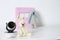 Baby camera with toys and photo album on table against white background. Video nanny