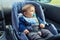 Baby car seat for safety. Happy Boy sitting in a car in safety chair. Protection in the car