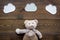 Baby care. Newborn baby concept. Baby sleep concept. Teddy bear toy near clouds on dark wooden background top view