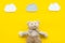 Baby care. Newborn baby concept. Baby sleep concept. Teddy bear toy near clouds on yellow background top view copy space