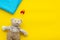 Baby care. Newborn baby concept. Teddy bear toy near pacifier on yellow background top view space for text