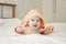 Baby Caucasian girl boy 5 months crawls out under towel, cheerful laughing open mouth, soft focus