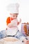 Baby chef sifting flour isolated on white background