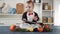 Baby chef sitting with ladle and vegetables