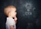 Baby child at the blackboard with chalk drawn bulb symbol ideas