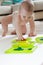 Baby child draws with colored paints hands, dirty feet. White list