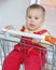 Baby child in shopping cart in supermarket