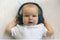 Baby child Toddler Happy smiling in wireless blue headphones on a white background. The concept of technology learning from birth