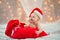 Baby in a Christmas hat with Santa Claus red bag