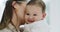 .Baby, closeup and face kiss with mom and smile in a family home feeling happy. Mother, child and relax with hug and