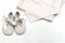 Baby clothes and shoes for babies from natural fabrics. Top view of the shoes with laces and shirt for the baby beige color that l