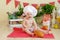 A baby in a cook`s hat sits in a beautiful photo zone with flour and vegetables, a baby cook, a child with flour and bread