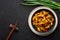 Baby Corn Manchurian dry looks like Schezwan Baby Corn in black bowl at dark slate background