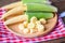 Baby corn on wooden plate, Fresh young baby corn for cooking health food, Close up raw organic baby corn on tablecloth background