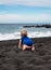 Baby crawling on Playa la Arena black volcanic sand beach