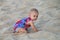 Baby crawling in a soft beach sand