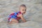 Baby crawling in a soft beach sand