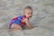 Baby crawling in a soft beach sand