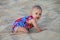 Baby crawling in a soft beach sand