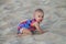 Baby crawling in a soft beach sand