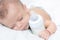 Baby curled up sleeping on a blanket with feeding bottle