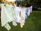 Baby cute clothes hanging on the clothesline outdoor. Child laundry hanging on line in garden