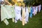 Baby cute clothes hanging on the clothesline outdoor. Child laundry hanging on line in garden