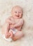 Baby, cute and laugh in bedroom, blanket and playtime in diaper for child development in happiness. Infant, kid and