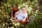 Baby in daisies, little girl in a daisy wreath in summer on the lawn