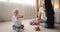 Baby daughter and mother playing with toy blocks in bedroom