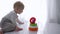 Baby development, cute child boy is played with educational toy pyramid in bright room