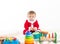 Baby disguised as santa claus surrounded by toys