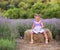 Baby in a dress plays hay in a lavender field