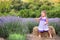 Baby in a dress plays hay in a lavender field