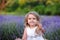 baby in a dress plays with hay in a lavender field