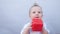 Baby drooling bubbles on the lips a toddler play with a cube at home. Little boy son portrait close-up. Little baby