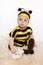 Baby earing bee costume sitting on the floo