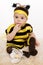 Baby earing bee costume sitting on the floo
