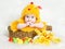 Baby in Easter basket with eggs in chicken hat