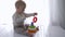 Baby educational, infant boy is played with toy tower in bright room
