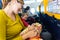 Baby entertaining in the arms of his mother sitting in the seat of an airplane during a long trip