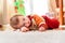 Baby entertains in winter lying on the carpet in his living room