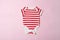 Baby fashion concept on a pink background. Striped bodysuit