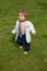 Baby fashion. Funny little business man in suit, jacket and necktie. Cute little baby on the meadow field. Toddler child